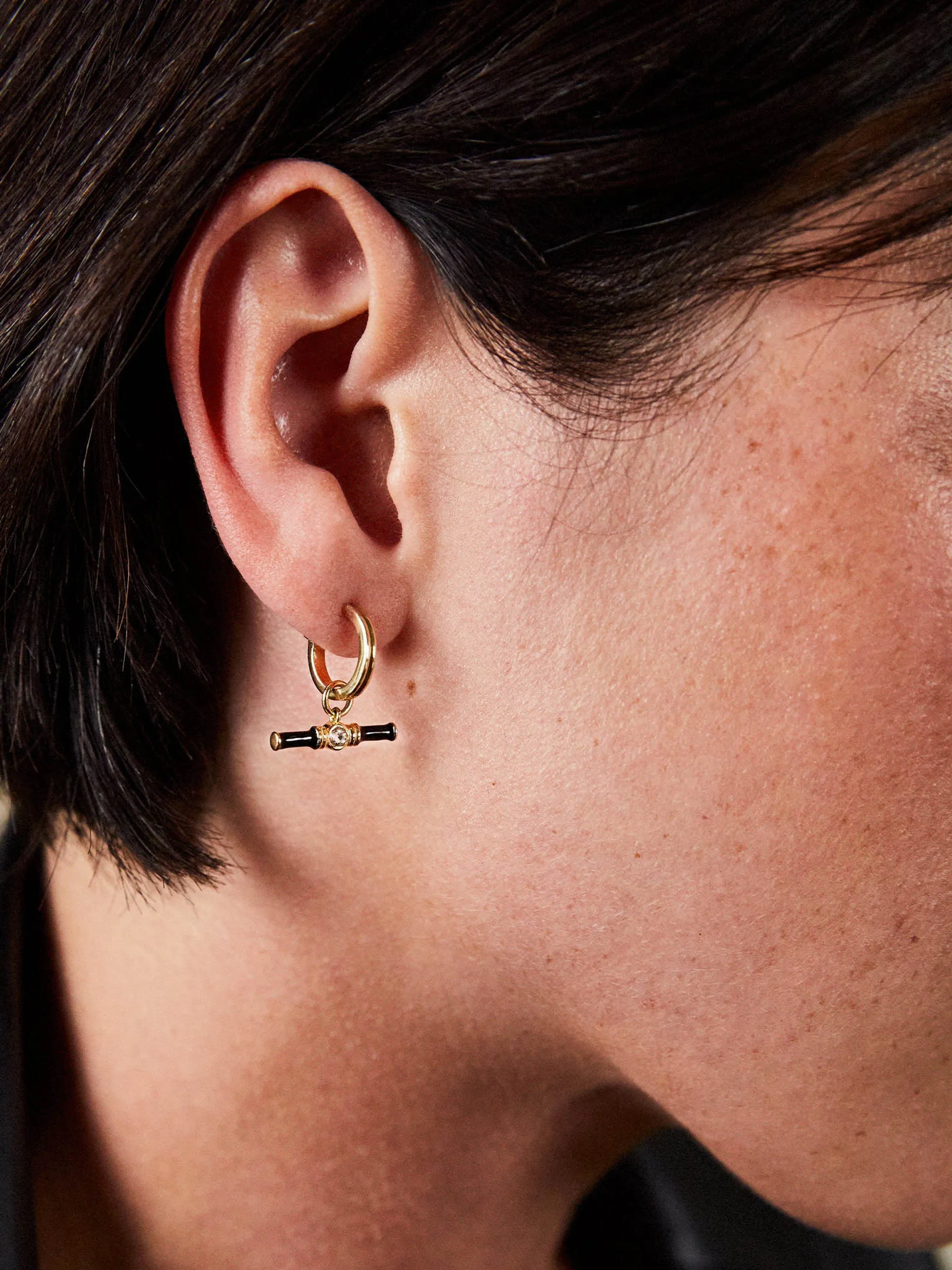 Gold Dyllan hoop earrings with black enamel t-bar charms
